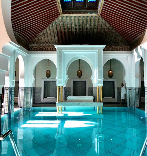 Bassin bleu et arcades sculptées d'un hammam