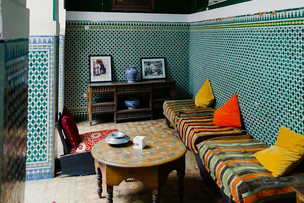 Salon aux banquettes colorées et murs de zellige