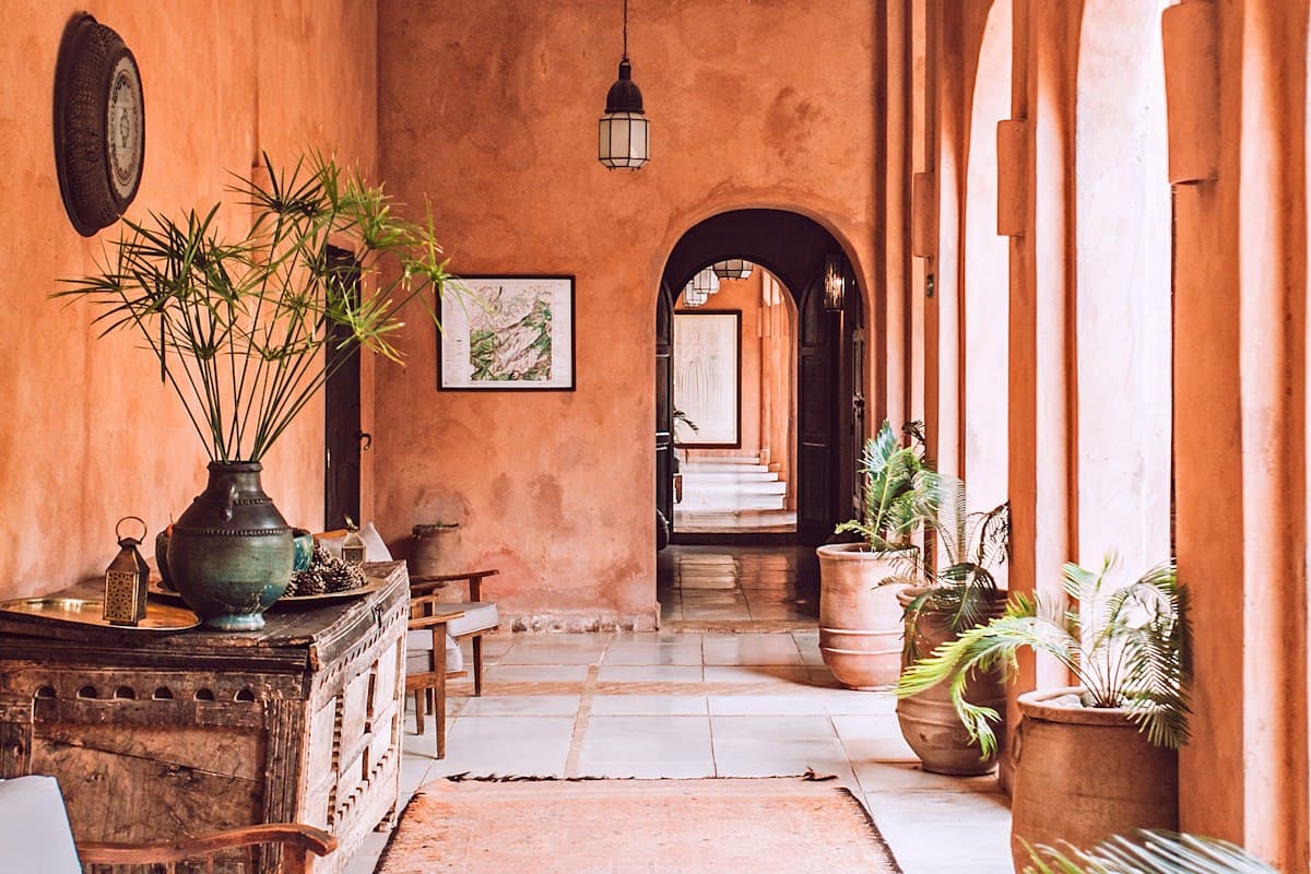 Galerie en arcades couleur terre menant à la chambre